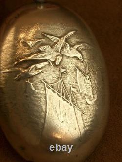 Beautiful ancient silver bell with a decoration of seagulls and swallows.