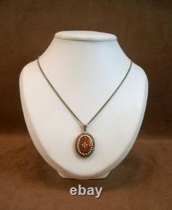 Beautiful old pendant in solid silver and Bressan enamels on a red background