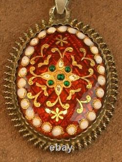 Beautiful old pendant in solid silver and Bressan enamels on a red background